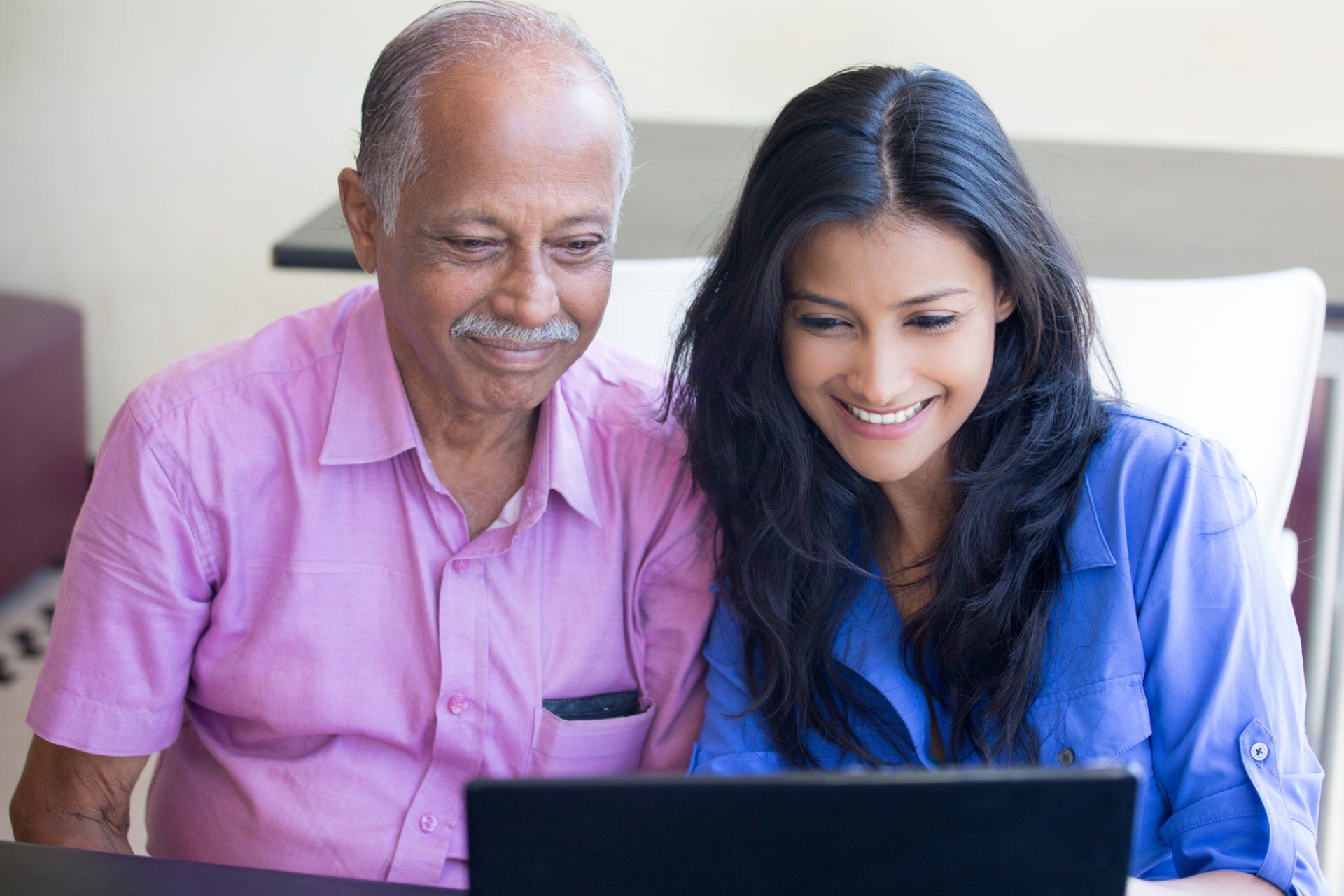 Older father and adult daughter using a computer together