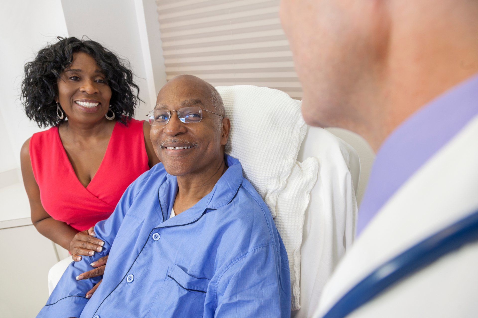 Doctor speaking with a hospital patient and his wife