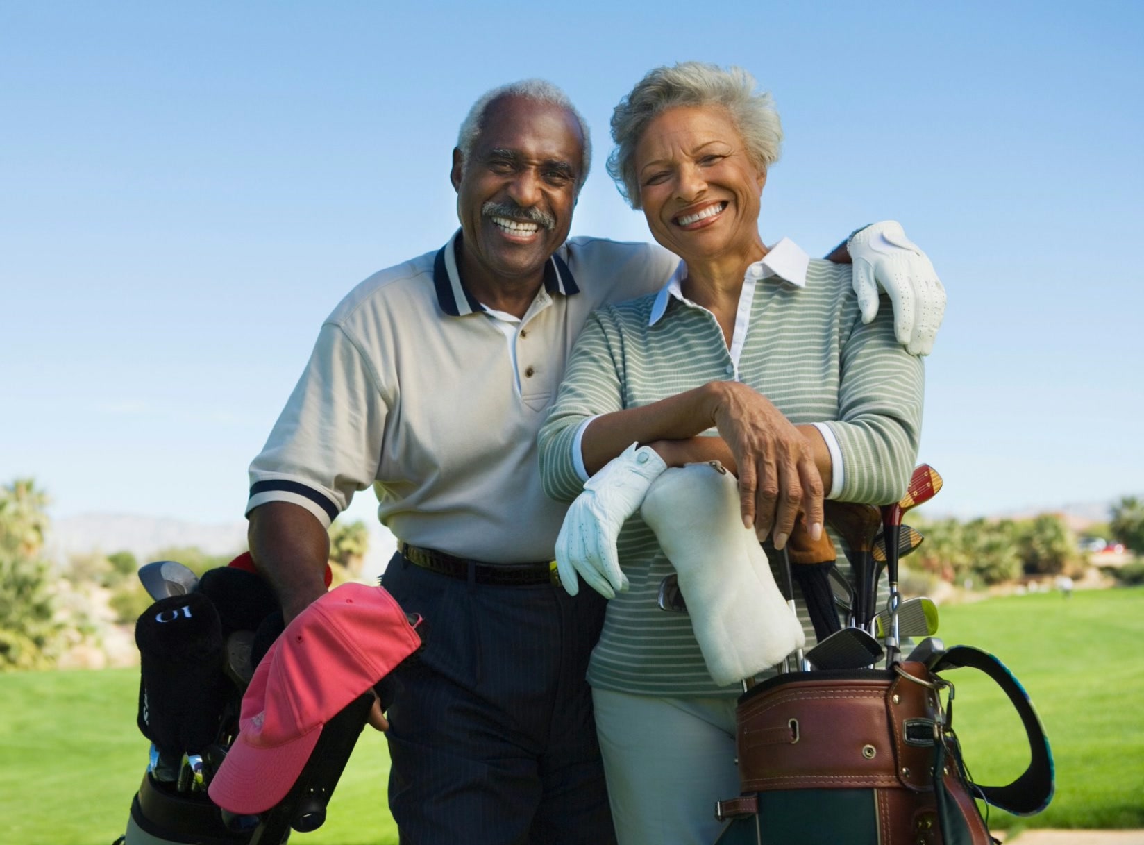 Older couple posing with golf equipment